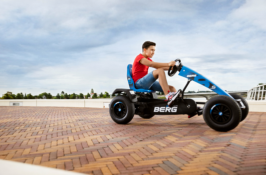 Child riding BERG Super Blue pedal go-kart outdoors