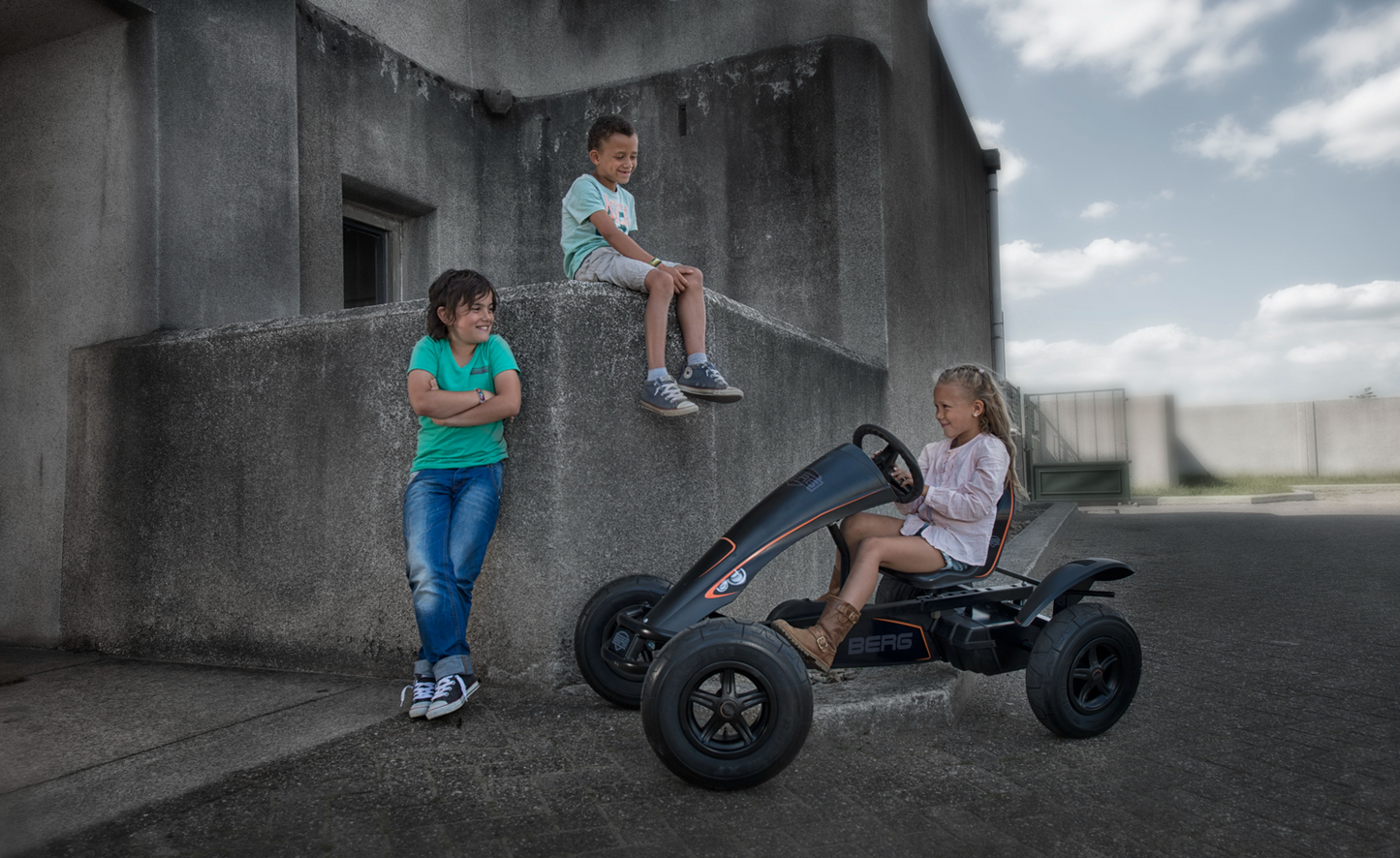 Child riding BERG Black Edition pedal go-kart outdoors