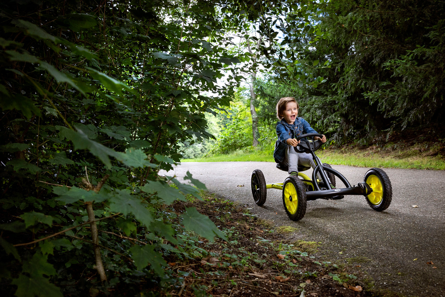 Child riding BERG Buddy Cross pedal go-kart outdoors