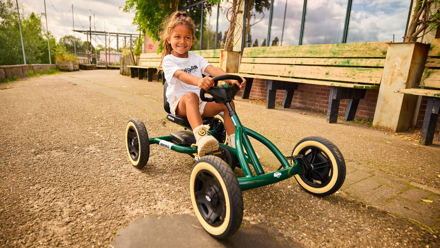 Child riding BERG Buddy Retro Green pedal go-kart outdoors
