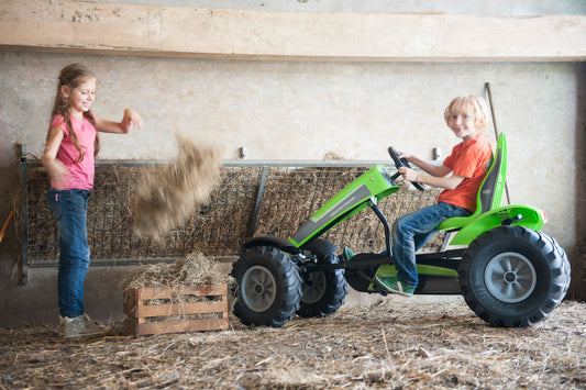 Child riding BERG Deutz pedal tractor outdoors