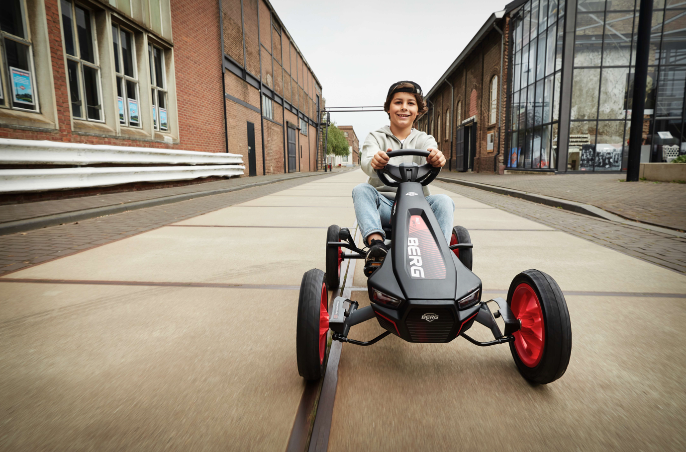 Child riding BERG Rally APX Red 3 Gear pedal go-kart outdoors