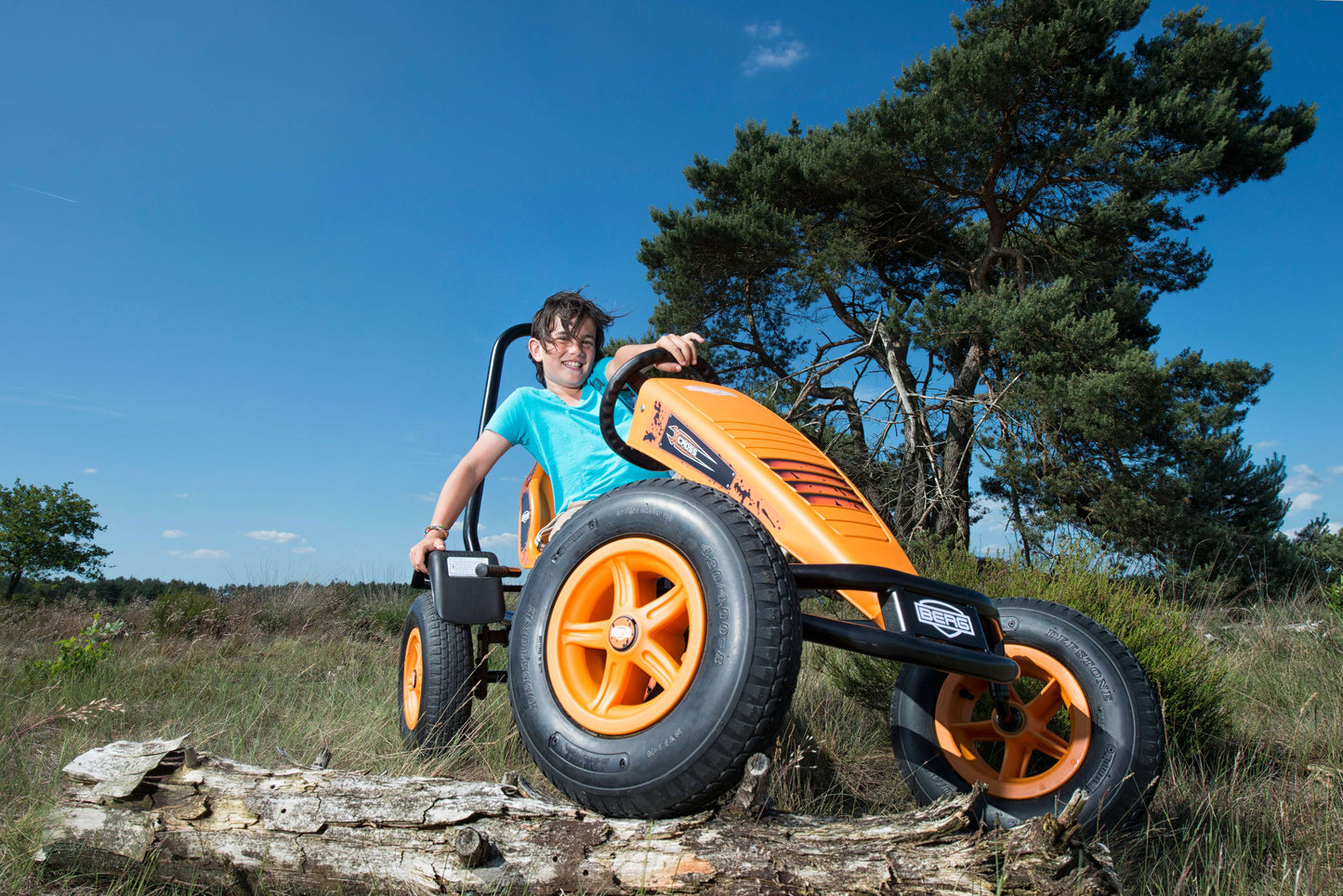 Child riding BERG X-Cross pedal go-kart outdoors