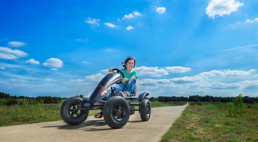 Child riding BERG Black Edition pedal go-kart outdoors