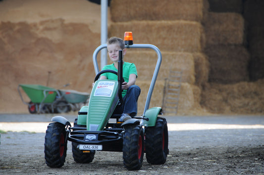 Child riding BERG Fendt pedal tractor outdoors