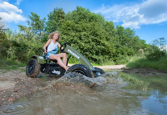 Child riding BERG Jeep pedal go-kart outdoors