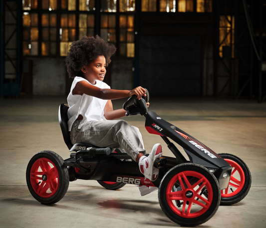 Child riding BERG Rally APX Red 3 Gear pedal go-kart outdoors