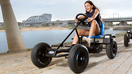 Child riding BERG Rapid Blue pedal go-kart outdoors
