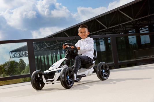 Child riding BERG Reppy BMW pedal go-kart outdoors