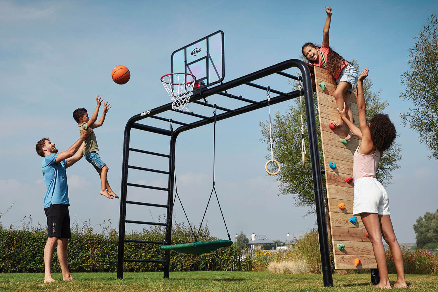 BERG PlayBase frame with swing accessories, including seat swing, trapeze bar, and disc swing, set up in an Irish backyard for active play.
