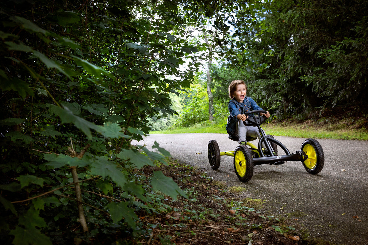 Child riding BERG Buddy Cross pedal go-kart outdoors