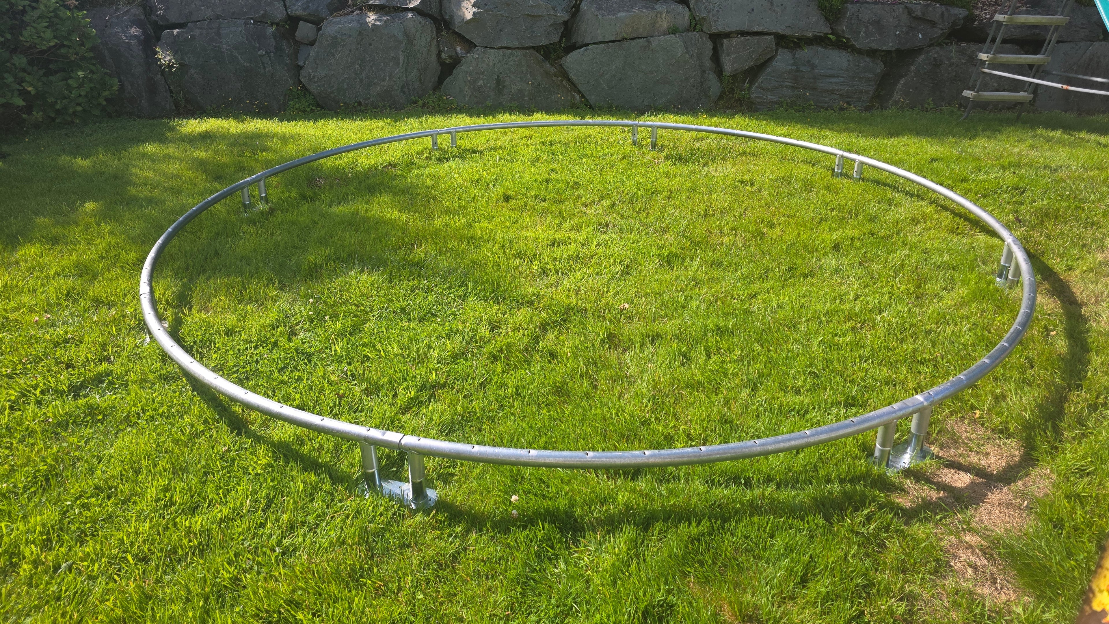 Flat green grass lawn before starting the excavation for a Berg inground trampoline installation.