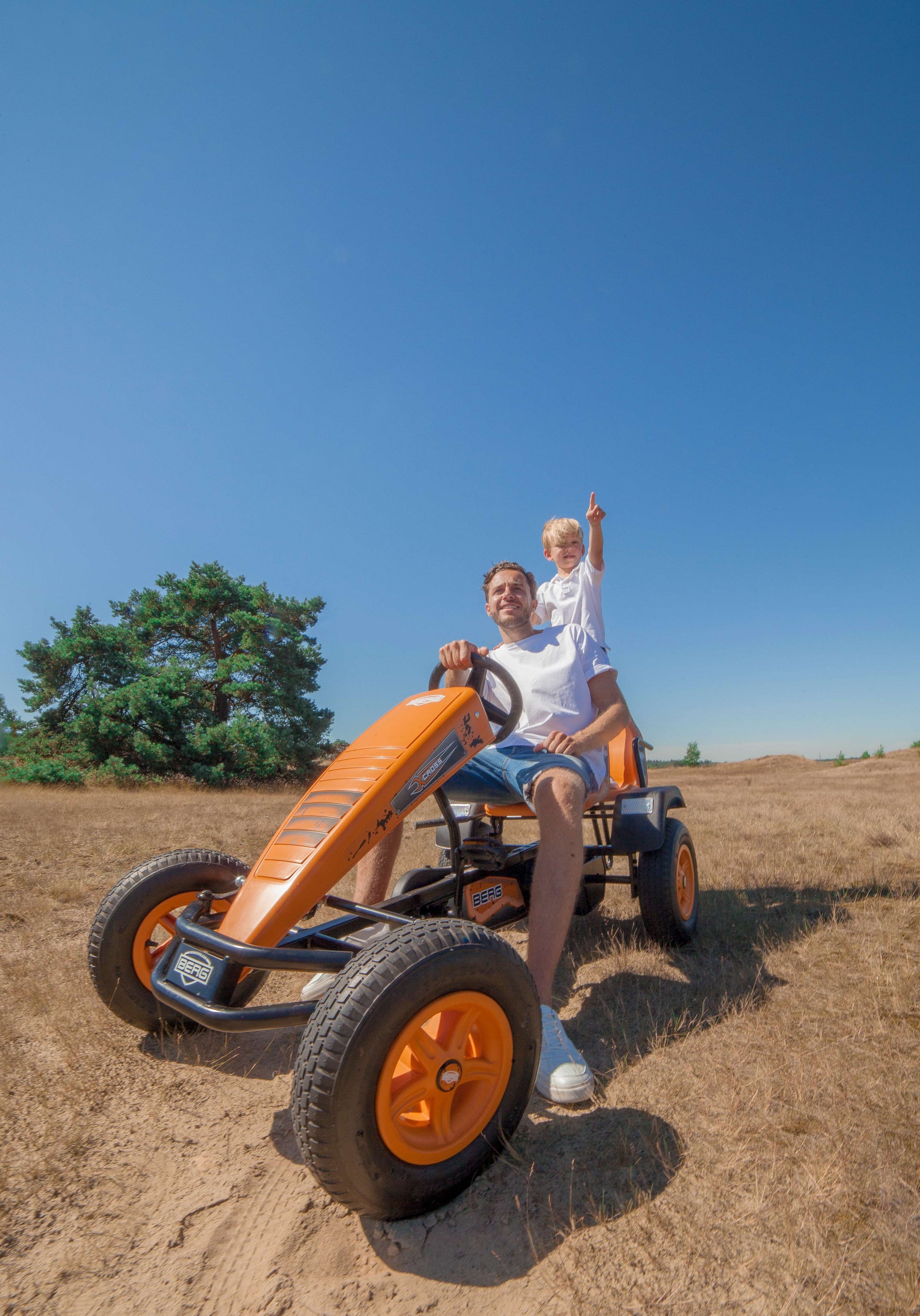 Child riding BERG X-Cross pedal go-kart outdoors