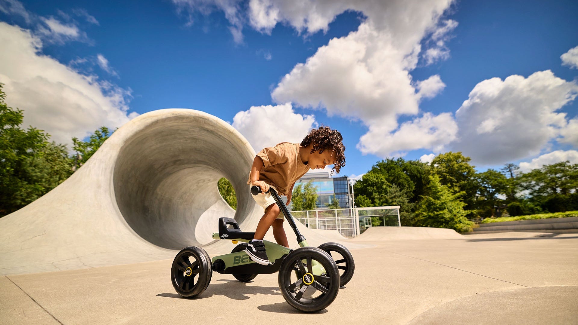 Child enjoying outdoor play with the BERG Buzzy Green pedal go-kart