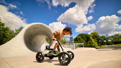 Child enjoying outdoor play with the BERG Buzzy Green pedal go-kart