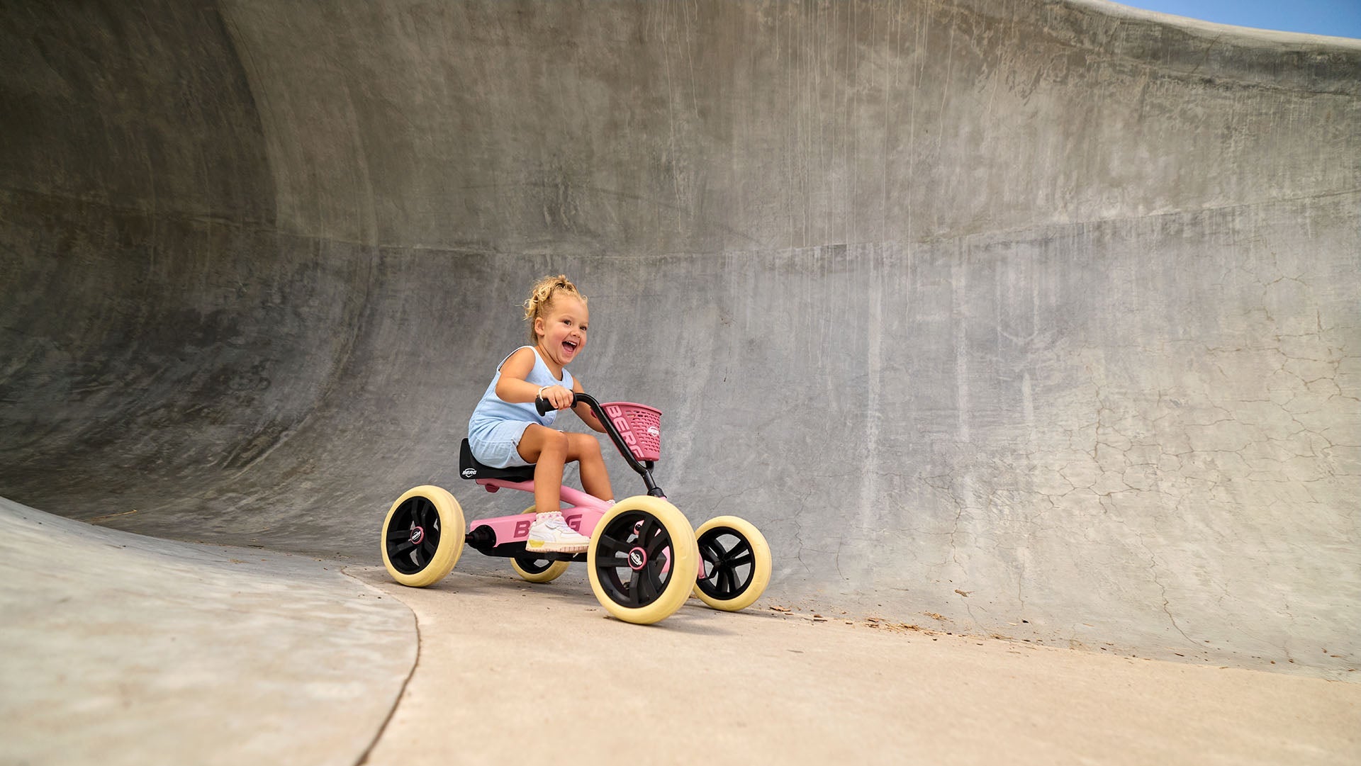 Child enjoying outdoor play with the BERG Buzzy Pink pedal go-kart