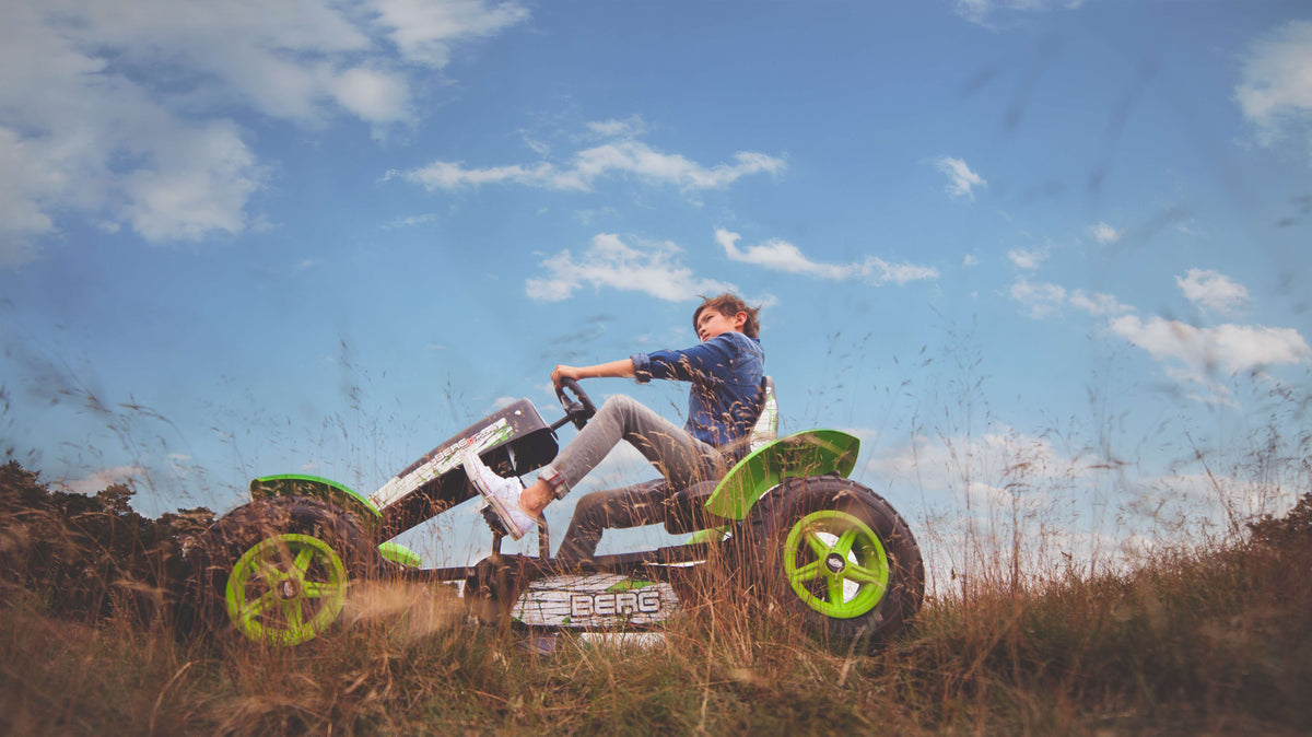 Child riding BERG X-Plore pedal go-kart outdoors
