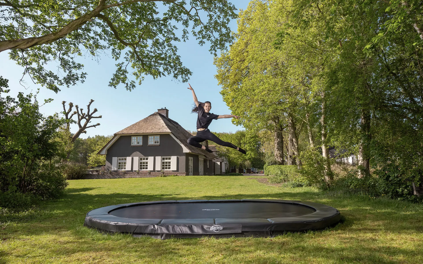 Child jumping on BERG Grand Champion InGround rectangular trampoline